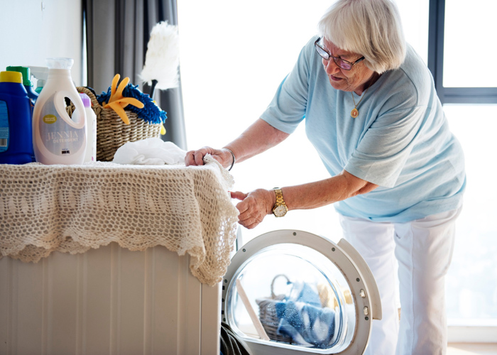 mujer mayor poniendo lavadora